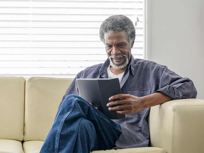 Older man reading screen.