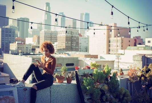 Lady at the rooftop, city skyline in the background.